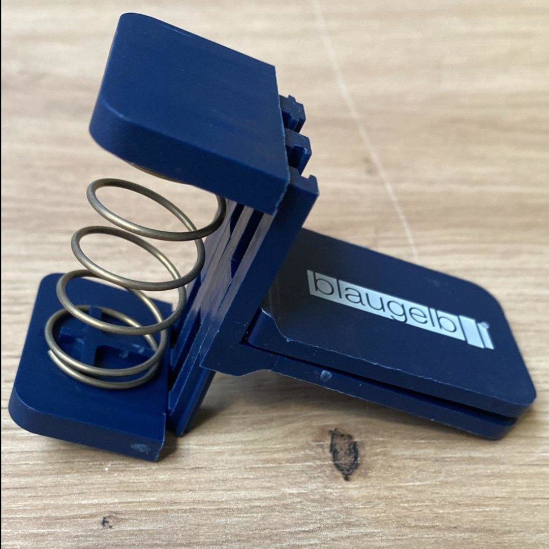 Clema din plastic cu arc blaugelb pentru mentinerea in stare rulata a sulurilor cu o latime de maxim 30 mm
